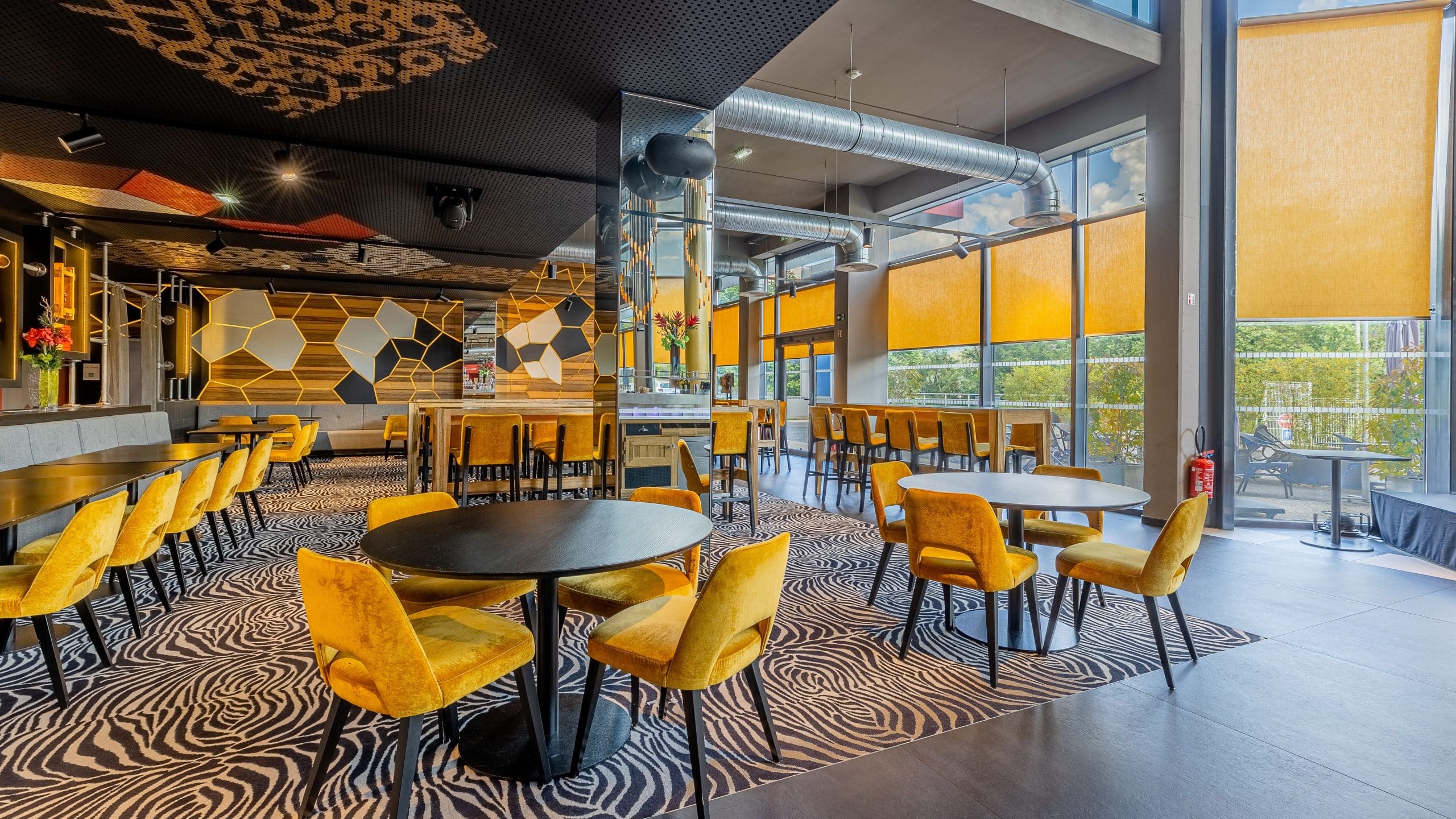 Restaurant E Motion Annecy avec de multiples tables et chaises jaunes pour tous types d'événements.