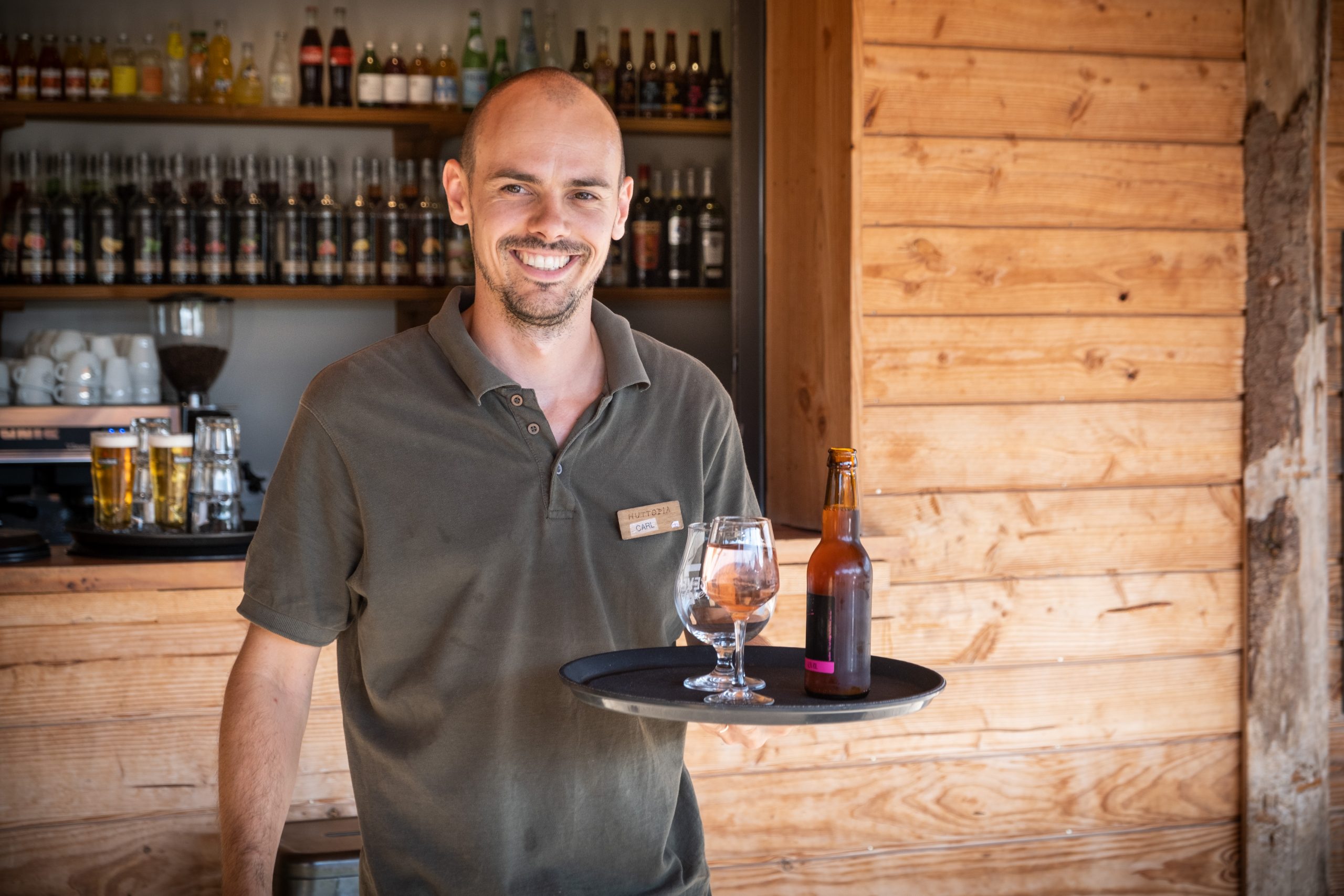 Serveur souriant au bar snack de Huttopia Sud Ardèche